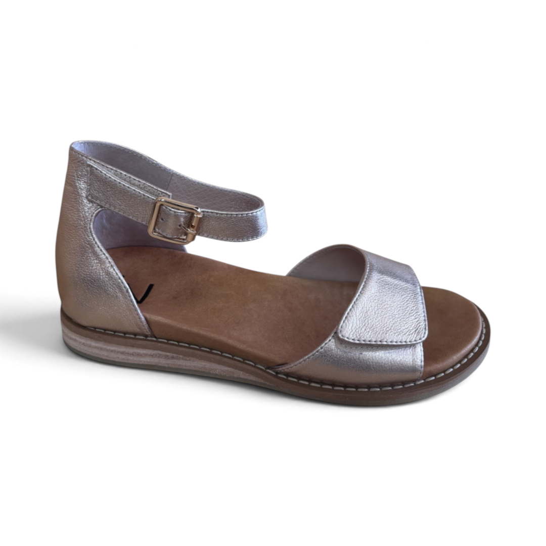 The Happy Shoe Shop Via Nova TJ Jamie silver metallic leather sandals with an adjustable ankle strap and flat sole.