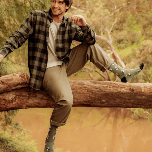 The Happy Shoe Shop Bamboozld men's green bamboo socks with kookaburra pattern. Model is wearing them with casual attire.