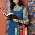 The Happy Shoe Shop Bookshelf Boulevard Book Stack Box Bag is a unique vegan leather bag designed as a stack of colorful books. Features include embossed titles and antique brass hardware.