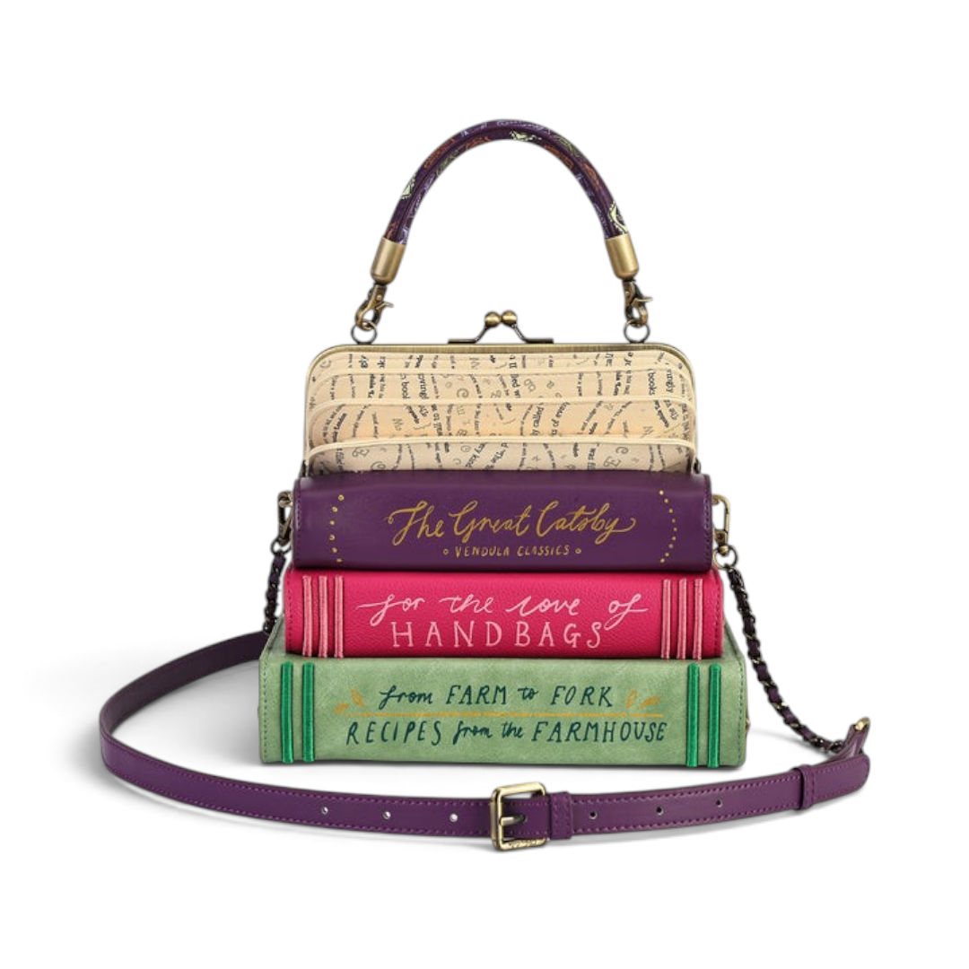 The Happy Shoe Shop Vendula London book stack handbag in purple, pink, and green vegan leather with a crossbody strap.