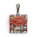 The Happy Shoe Shop Bookshelf Boulevard Pods Case, a small vegan leather case with a bookshelf print and red trim, featuring a gold embossed title.