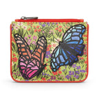 The Happy Shoe Shop Yoshi leather coin purse featuring colourful butterfly appliqués on a floral green background.