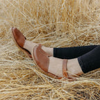 The Happy Shoe Shop Josef Seibel Rosalie 42 brown leather closed-toe sandals with T-strap design worn in a field.