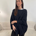 The Happy Shoe Shop Cinnamon Creations navy chunky cable knit oversized poncho worn by a woman