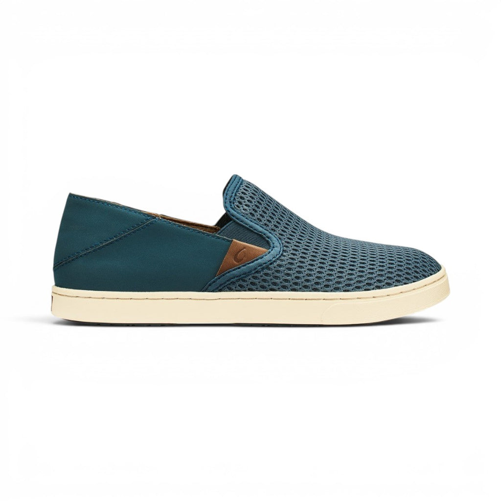 The Happy Shoe Shop Olukai Pehuea slip-on sneakers in stormy blue with a breathable mesh upper and cream rubber sole.