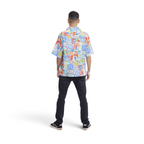 Back view of a man wearing a The Happy Shoe Shop Orientique short sleeve shirt with a colourful travel-themed print.