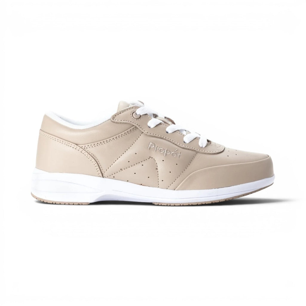 The Happy Shoe Shop Propet Washable Walker women's beige leather sneakers with white laces and soles. Features perforated details and a low-top design.