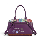 The Happy Shoe Shop Vendula London purple vegan leather bowler bag with bookshop print and detachable shoulder strap.