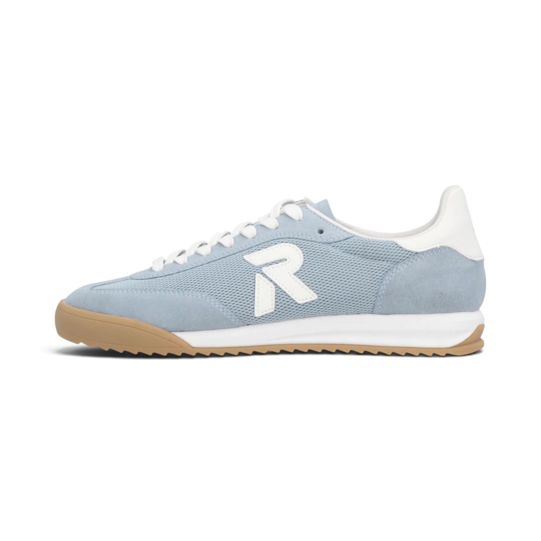 The Happy Shoe Shop Rieker blue textile sneaker with white R logo, white laces, and a gum rubber outsole.