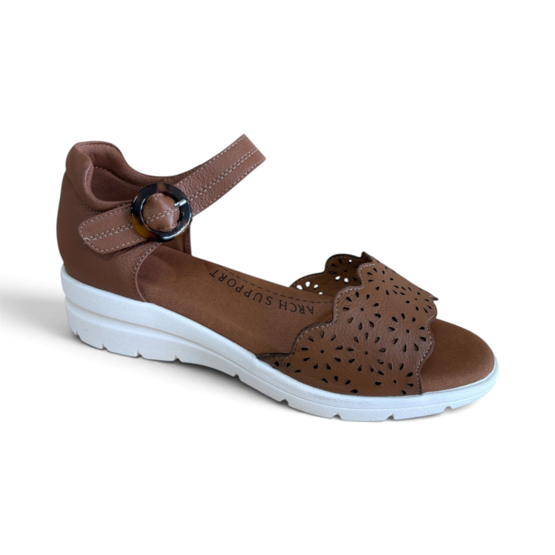 The Happy Shoe Shop Via Nova Rusk tan leather wedge sandals with cutout details, white sole, and buckle strap.