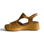 The Happy Shoe Shop Rilassare Petula wedge sandals in tan leather with laser-cut floral pattern and ankle strap.