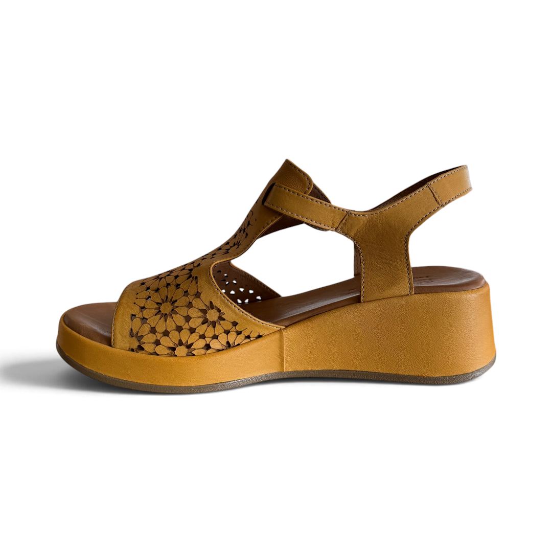 The Happy Shoe Shop Rilassare Petula wedge sandals in tan leather with laser-cut floral pattern and ankle strap.
