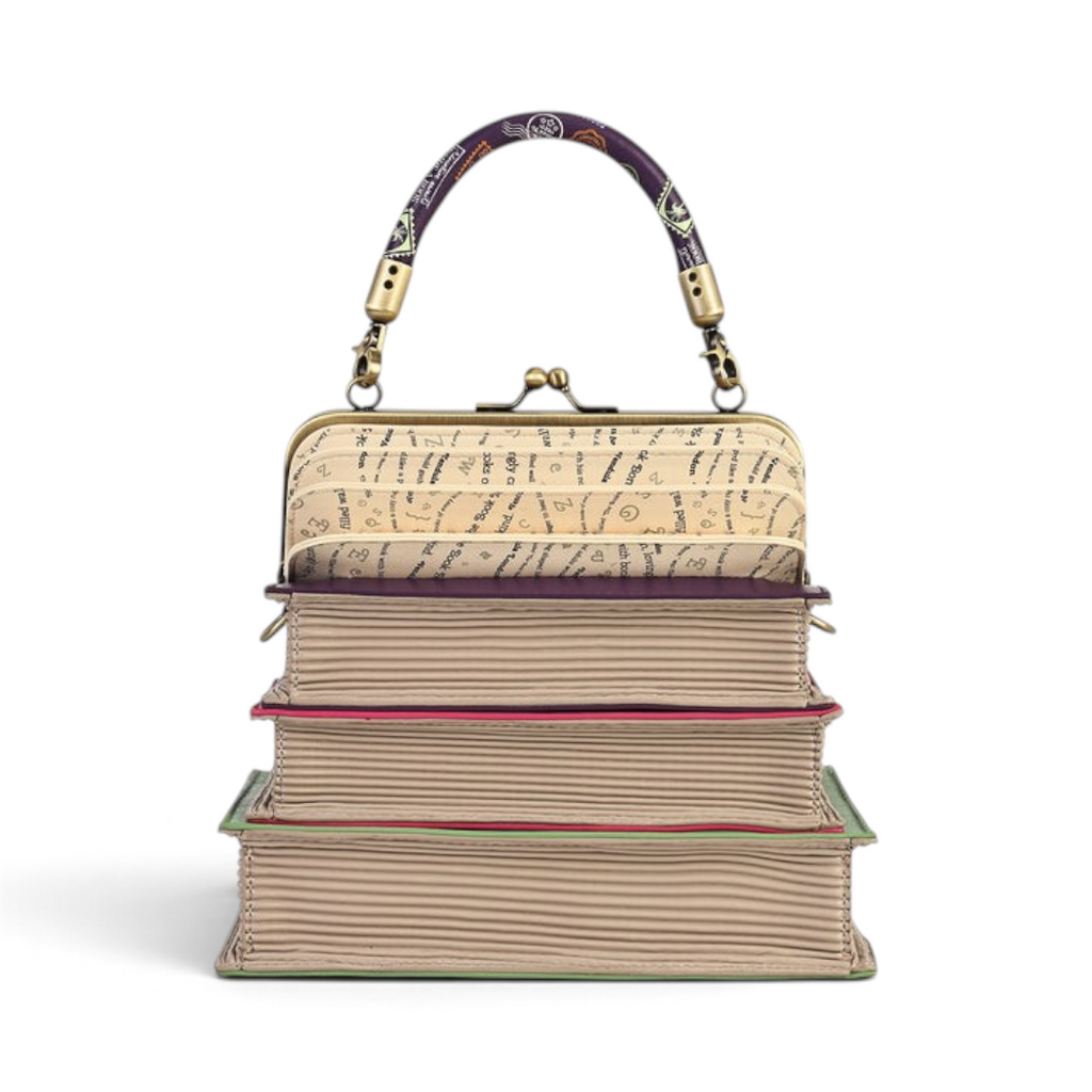 The Happy Shoe Shop Vendula London book stack handbag with a concertina top, clip frame, and purple patterned handle.
