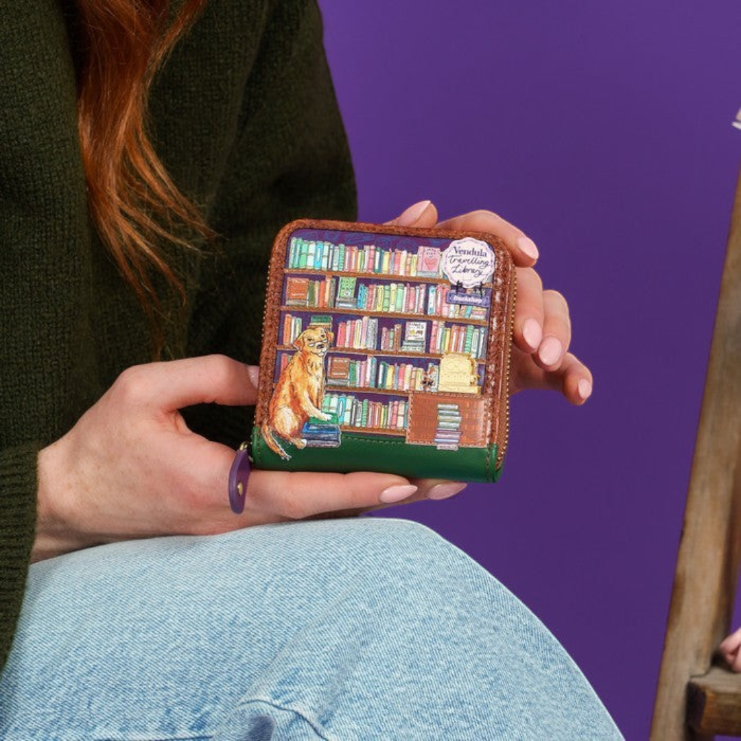The Happy Shoe Shop Vendula London square wallet featuring a whimsical bookshop print and dog on vegan leather