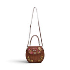 The Happy Shoe Shop Vendula London amber wicker basket bag with floral embroidery and vegan leather flap