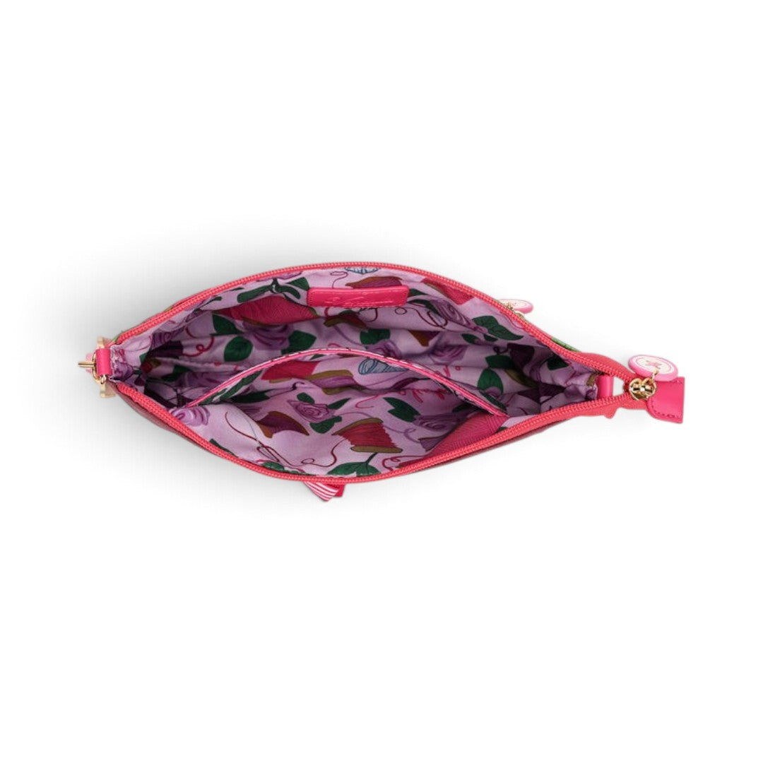 The Happy Shoe Shop Vendula London Kate bag interior showing pink fabric lining with sewing-themed print and pocket.