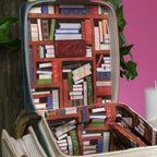 The Happy Shoe Shop Vendula London Book Stack Box Bag with a bookshelf print lining and vegan leather details.