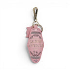 The Grand Vendula Hotel Key Charm by The Happy Shoe Shop, a pink vegan leather keychain with embossed lettering and antique gold hardware.