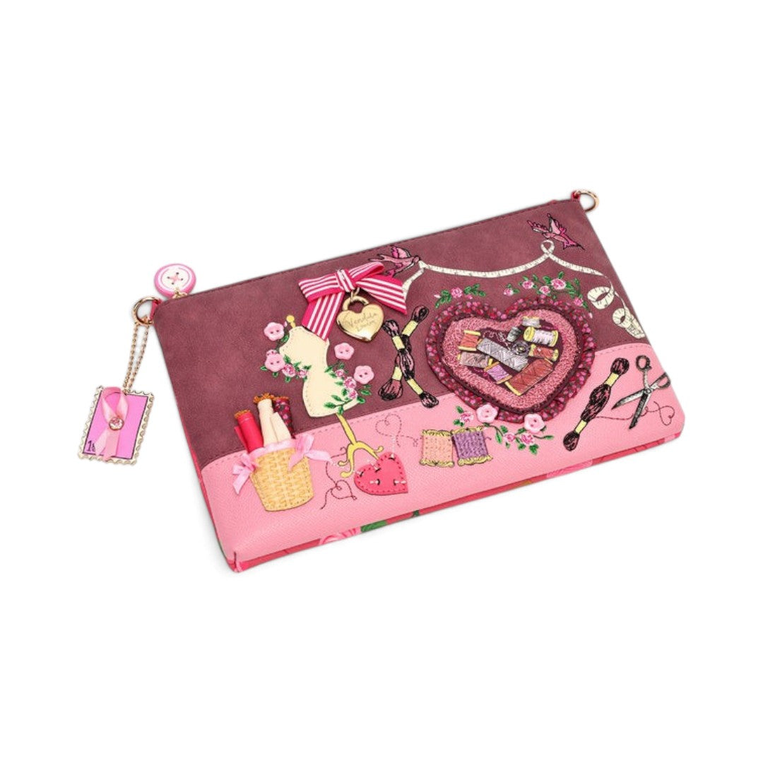 The Happy Shoe Shop Vendula London vegan leather scrapbook bag with sewing-themed embroidery and pink ribbon accents.