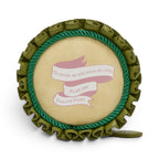 The Happy Shoe Shop Vendula London Shakespeare's Twelfth Night round coin purse in light tan vegan leather with green trim and pink ribbon detail.