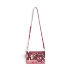 The Happy Shoe Shop Vendula London vegan leather crossbody bag with pink sewing-themed scrapbook artwork and strap.