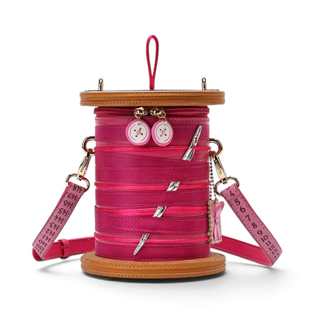 The Happy Shoe Shop Vendula London sewing box bag in raspberry vegan leather with thread reel and button details.