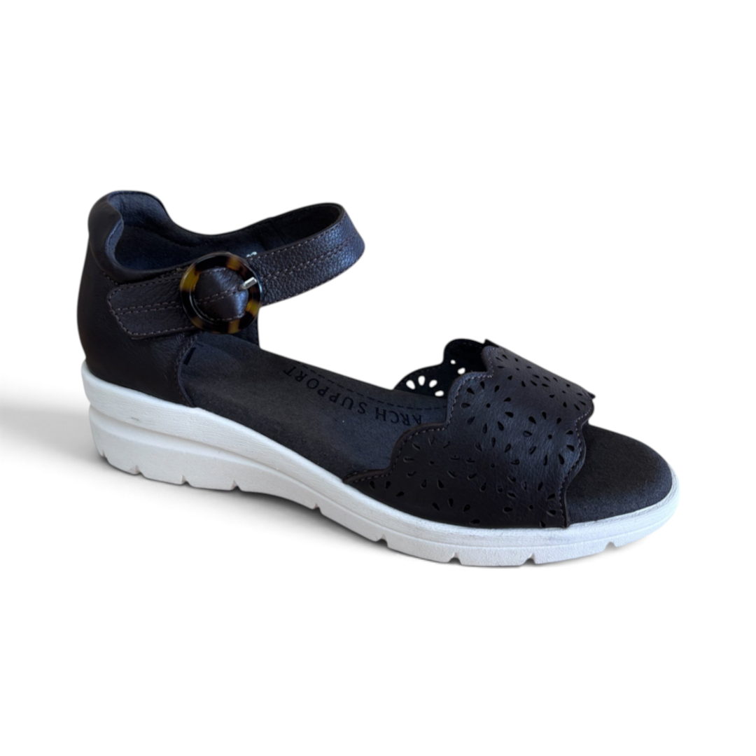 The Happy Shoe Shop Via Nova Rusk black leather wedge sandals with cutout details and a white sole.