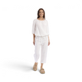 Model wearing white Orientique Escape linen blend cropped culotte pants with a drawstring waist.
