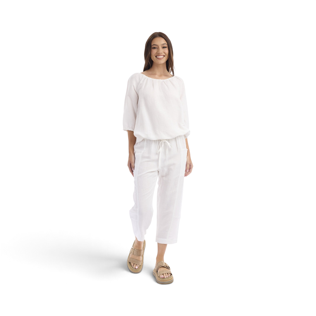 Model wearing white Orientique Escape linen blend cropped culotte pants with a drawstring waist.