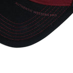 The Happy Shoe Shop Wrangler Odin trucker cap brim in black with cognac contrast stitching and embroidered text.